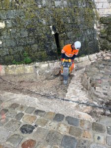 Travaux de remblaiement de fouille blindée à l'aide d'une plaque vibrante