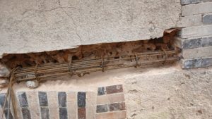 Réalisation d'une première passe de chainage : - découpe à l'outil diamant et démolition soignée de la maçonnerie existante - mise en place du ferraillage avec réalisation de scellement chimique pour ancrer les armatures dans la maçonnerie existante