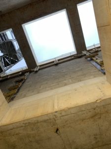 Voile en parpaings pleins avec poteaux et chaînages coffrées et coulés en place, coffrage des poteaux en cours