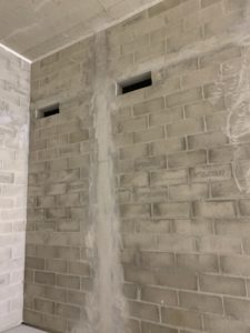 Voile en parpaings pleins avec poteaux et chaînages coffrées et coulés en place, réservations sur mesure