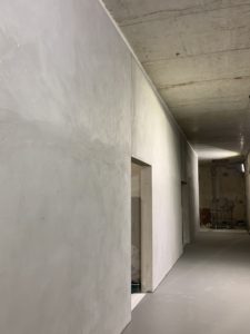 Voile en parpaings pleins avec enduits ciment sur parement et cordon coupe-feu en tête