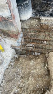 BATI-IDF massif ferraillé en fond de fouille, toupie béton prête à couler en partie haute — reprise en sous-œuvre post-sécheresse à Antony (92).