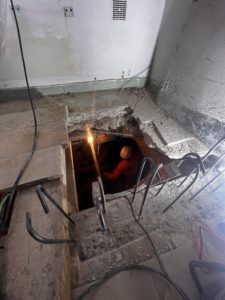 BATI-IDF compagnon au terrassement dans la fouille en sous-œuvre, accès par la trémie créée dans le plancher — reprise en sous-œuvre d'un immeuble, Argenteuil (95)
