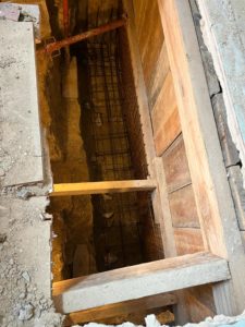 BATI-IDF cage d'armatures du voile en béton armé mise en place dans la fouille blindée, contre le blindage bois — reprise en sous-œuvre, Argenteuil (95)