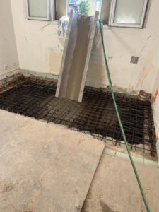 BATI-IDF reconstruction du plancher du sous-sol : ferraillage en place et bétonnage à la goulotte de la dalle en béton armé — reprise en sous-œuvre, Argenteuil (95)