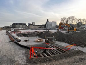 BATI-IDF démarrage du chantier des murettes-guides : tranchées ouvertes, cages d'armatures préfabriquées livrées sur la plateforme, dôme de la Salpêtrière en arrière-plan — îlot A7-A8 Austerlitz, Paris 13e