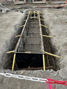 BATI-IDF double-murette-guide coffrée en long pour mega-barrette de paroi moulée, butons jaunes métalliques entre les deux murettes — îlot A7-A8 Austerlitz, Paris 13e