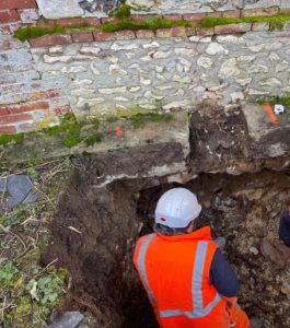 BATI-IDF fouille de reprise en sous-œuvre ouverte sous un mur ancien en brique et silex fissuré par la sécheresse — corps de ferme à Bernouville (27)