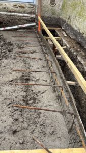 BATI-IDF bétonnage de la bêche de protection -1,50 m × 20 cm, cage ferraillée du chaînage en place, coulage en cours — pavillon Boissy-sans-Avoir (78).