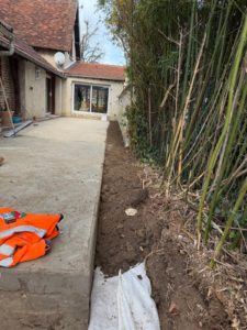 BATI-IDF trottoir périphérique bétonné fini en pied du pavillon avec la tranchée de drainage en cours de finalisation — Boissy-sans-Avoir (78).