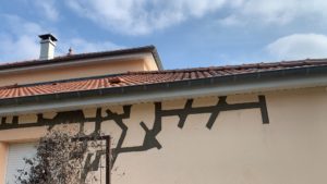BATI-IDF fissures structurelles cousues sur le pignon de la maison, mortier fibré gris visible dans les saignées avant ragréage de finition — reprise en sous-œuvre d'une maison à Bruley (54).