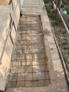 BATI-IDF cage d'armatures d'un massif de liaisonnement longitudinal, sol protégé par film polyane — reprise en sous-œuvre d'une maison à Bruley (54).