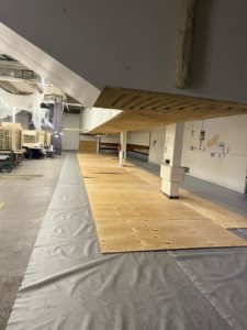 BATI-IDF pose des plaques de contreplaqué pour protéger le sol existant pendant la déconstruction — Centre de tri La Poste, Paris 17e.