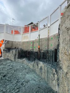 BATI-IDF vue de l'arase d'un panneau de paroi moulée entièrement démolie sur toute sa longueur, aciers en attente verticaux mis à nu et marquages au sol — prête pour le traitement des aciers et le coffrage. Puits OA 605 à Chelles.