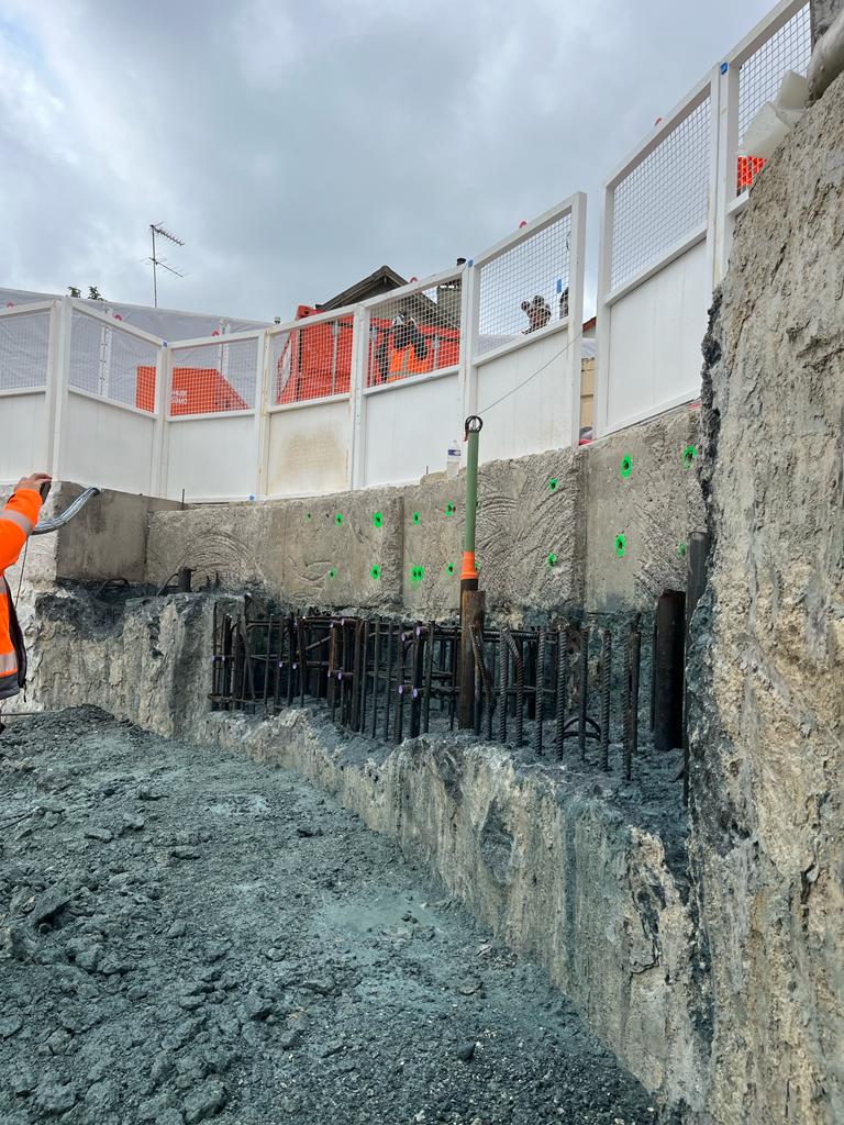 BATI-IDF vue de l'arase d'un panneau de paroi moulée entièrement démolie sur toute sa longueur, aciers en attente verticaux mis à nu et marquages au sol — prête pour le traitement des aciers et le coffrage. Puits OA 605 à Chelles.