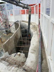 BATI-IDF tuyau d'alimentation de la pompe à béton descendant dans la fouille jusqu'à l'arase à reprendre du panneau de paroi moulée. Puits OA 605 à Chelles.