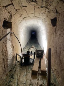 Galerie technique du Déversoir Nord avant curage — Coulis obstruant la conduite, Château de Fontainebleau (BATI-IDF)