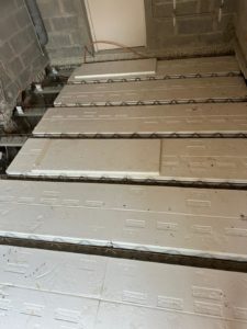 BATI-IDF plancher poutrelles béton + hourdis isolant polystyrène en cours de pose au-dessus du sous-sol, avant coulage de la dalle de compression — Herblay-sur-Seine (95).