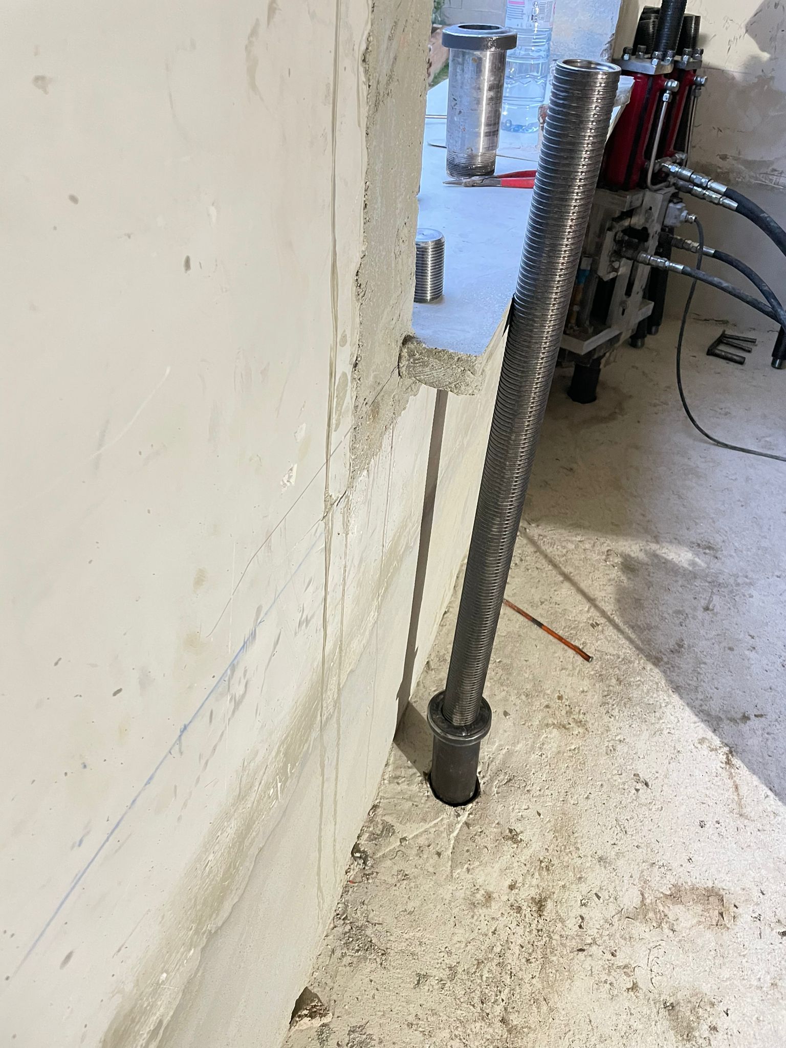 BATI-IDF micropieu métallique en cours de fonçage par vérinage au droit du mur porteur — reprise des descentes de charges, pavillon Montigny-lès-Cormeilles (95)