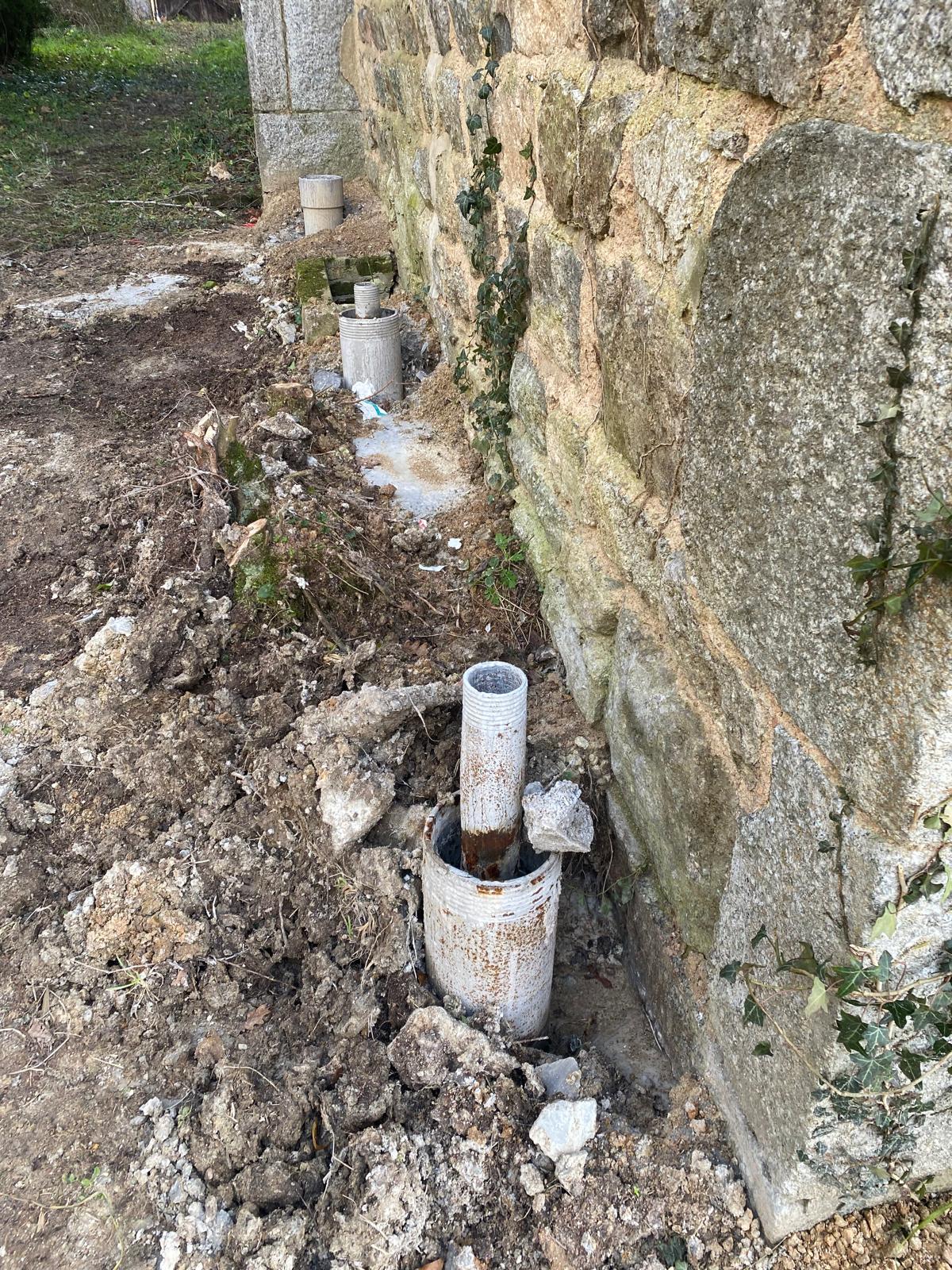 BATI-IDF têtes de micropieux en attente de récépage au pied du mur en moellon de l'église de Noailly — reprise en sous-œuvre, Loire