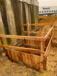 BATI-IDF coffrage bois neuf et soigné d'une passe de reprise en sous-œuvre en pied du mur béton existant, en limite d'un site industriel à Orly (94).