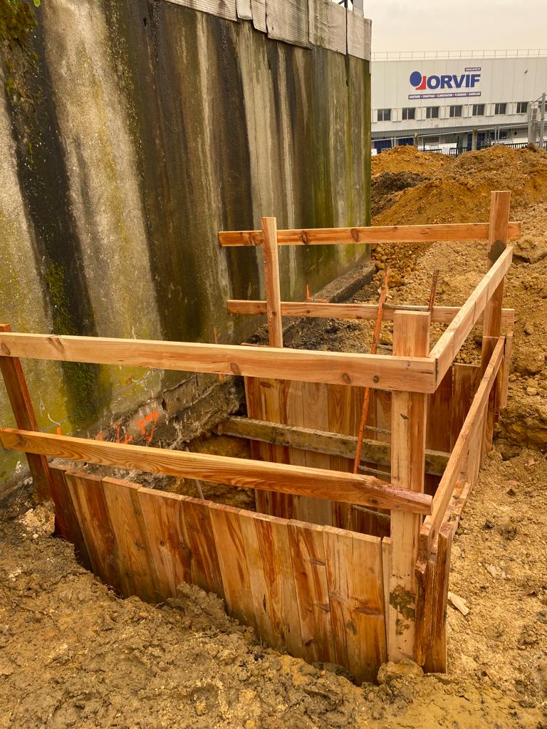 BATI-IDF coffrage bois neuf et soigné d'une passe de reprise en sous-œuvre en pied du mur béton existant, en limite d'un site industriel à Orly (94).