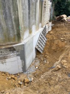 BATI-IDF nouvelle semelle béton armé coulée en pied du mur existant après décoffrage — phase finale de la reprise en sous-œuvre à Orly (94).