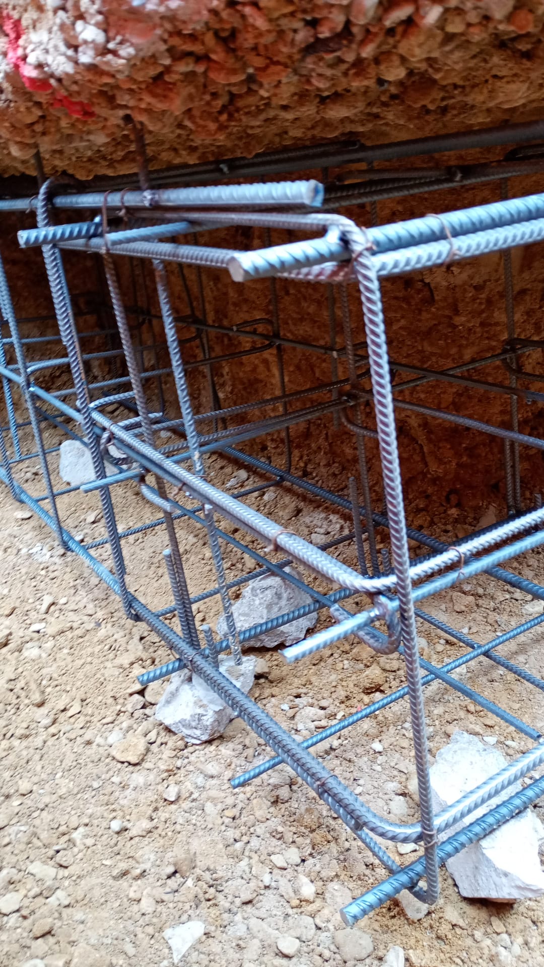 BATI-IDF cage d'armatures de la longrine de raidissement (section 0,60 × 0,50 m) en place dans la fouille blindée en sous-œuvre, prête au coffrage — pavillon Ouges (21).
