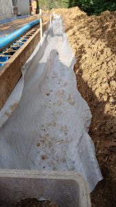 BATI-IDF tranchée de drainage périphérique le long de la longrine BA, géotextile blanc déployé en attente de la pose du drain — Ouges (21).