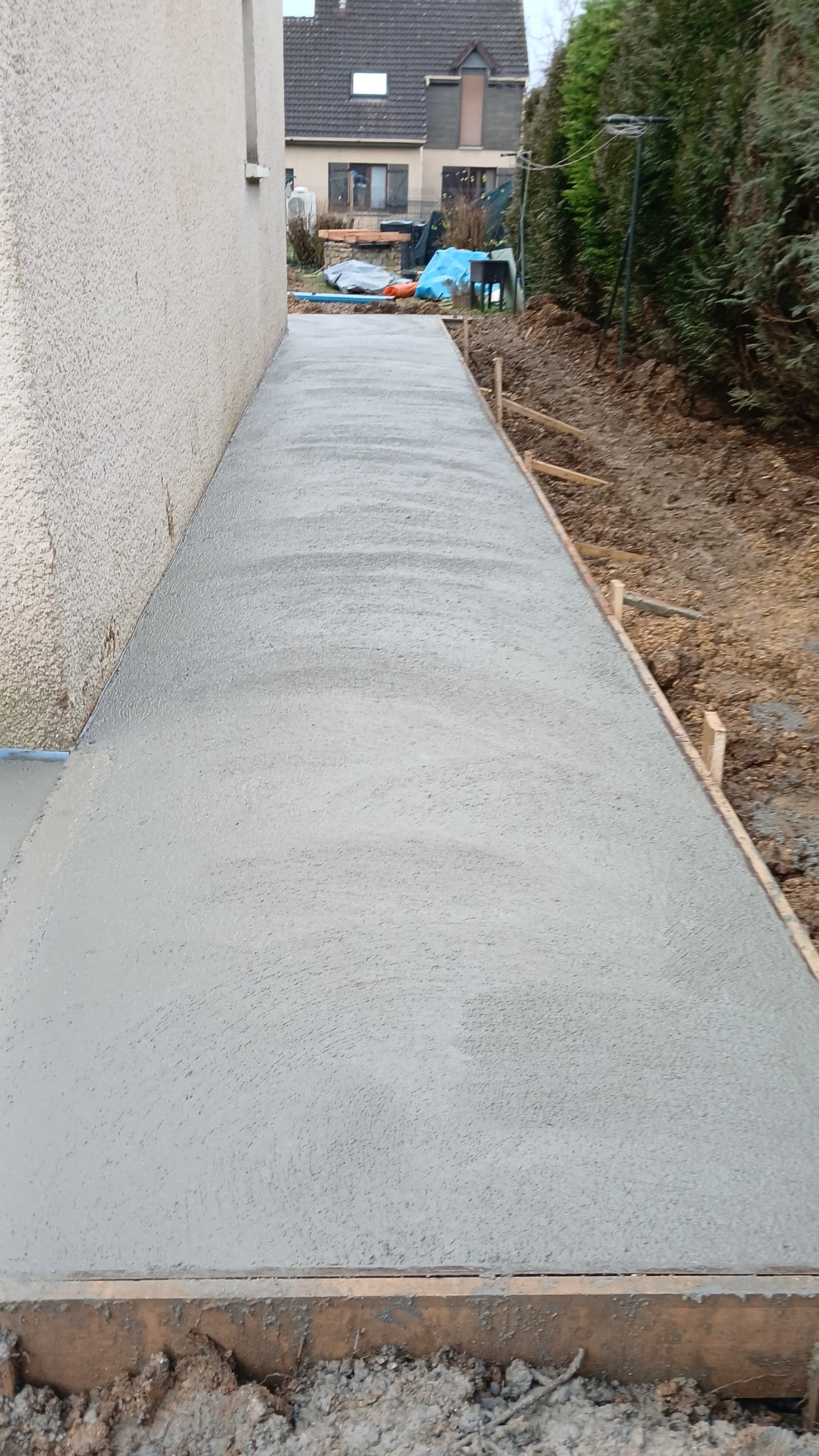 BATI-IDF vue longitudinale du trottoir périphérique bétonné fini le long du pavillon, finition propre prête à la livraison — Ouges (21).