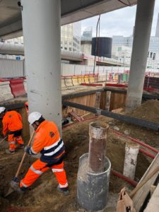 BATI-IDF terrassement manuel d'une fouille blindée au pied des piles de viaduc — chantier Ligne 15 du Grand Paris Express, La Défense, Puteaux (92)