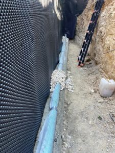 BATI-IDF pose de la nappe drainante sur le mur de soutènement étanché (enduit bitumineux) — Mimet (13).