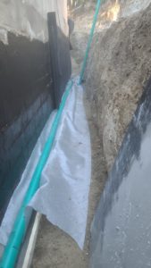 BATI-IDF tranchée drainante équipée (nappe, géotextile, drain) et canalisation d'évacuation le long du mur de soutènement — Mimet (13).